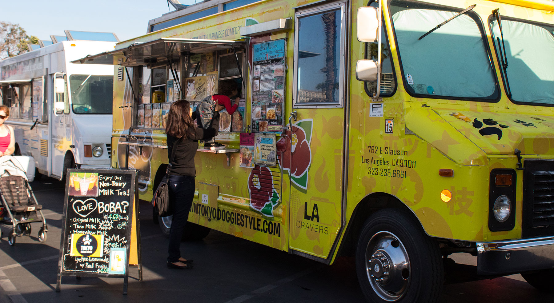 people ordering from food trucks at beach eats event