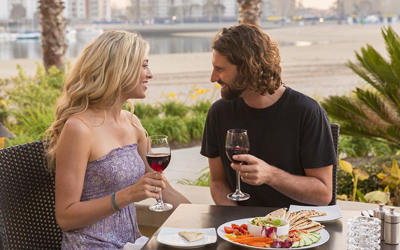 couple enjoying Valentine's Day dinner specials along beachfront restaurant