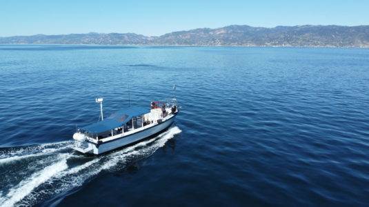 Boat in the ocean facing the mountains