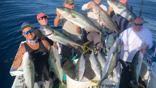 Group on a boat showing fish caught from fishing charter