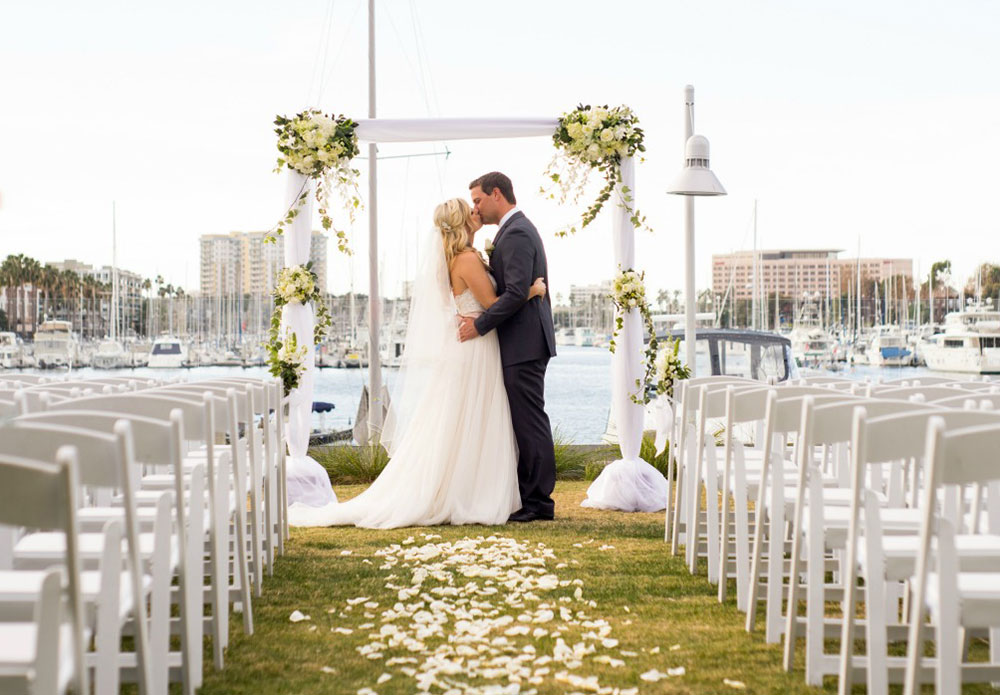 wedding couple kissing with marina in background