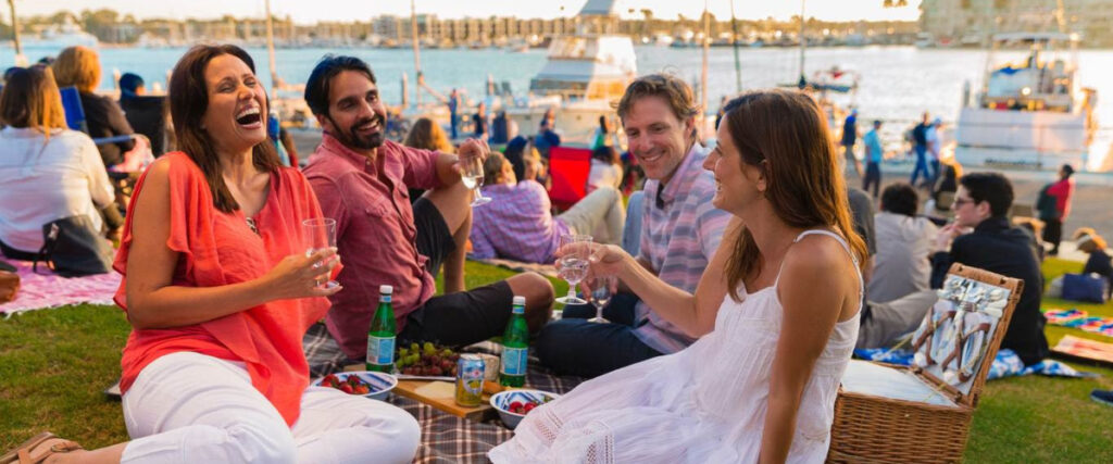 Group toasting at picnic by the ocean