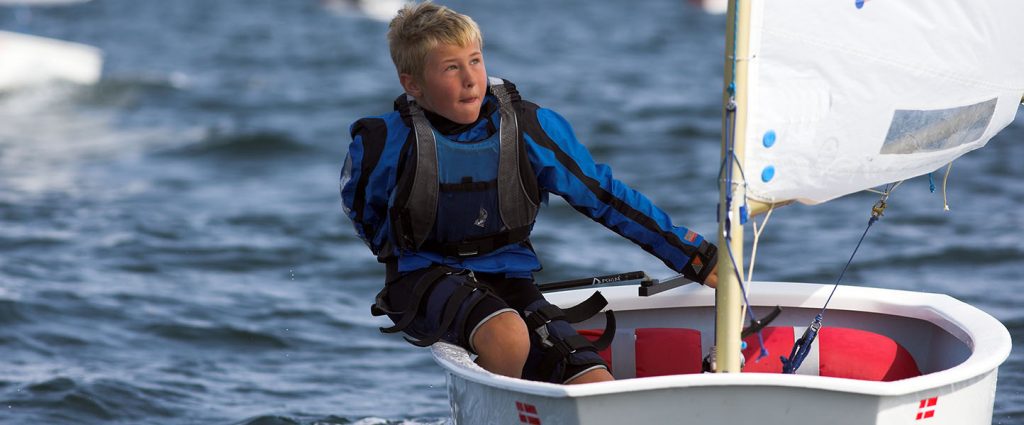 young boy learning how to sail with the wind