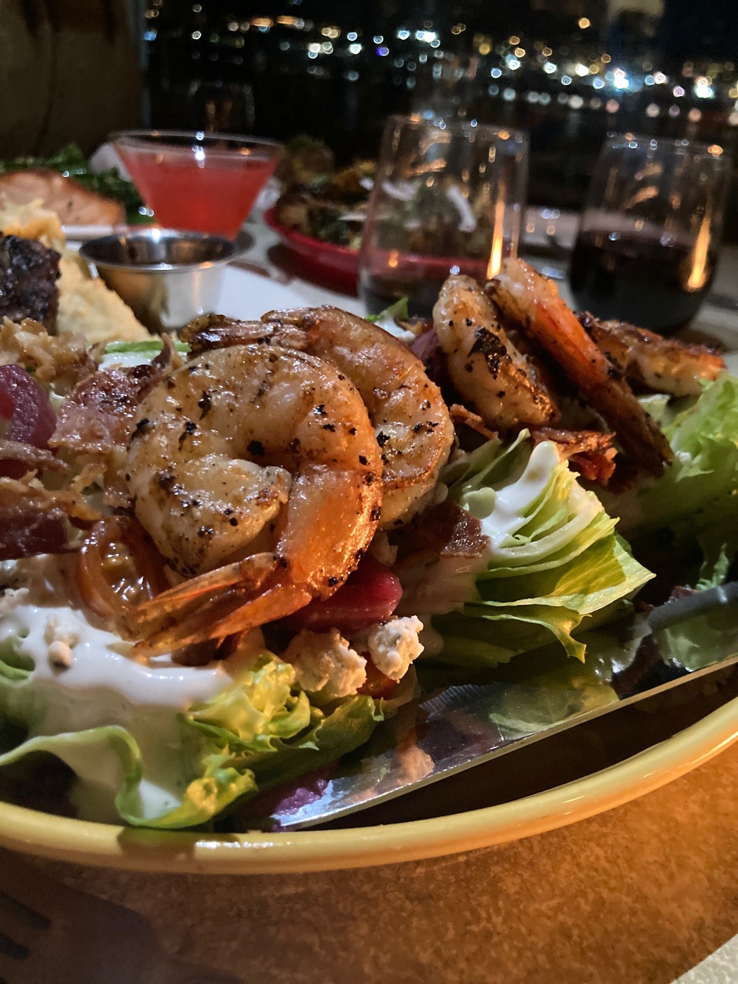 Shrimp salad with drinks at outdoor table facing harbor