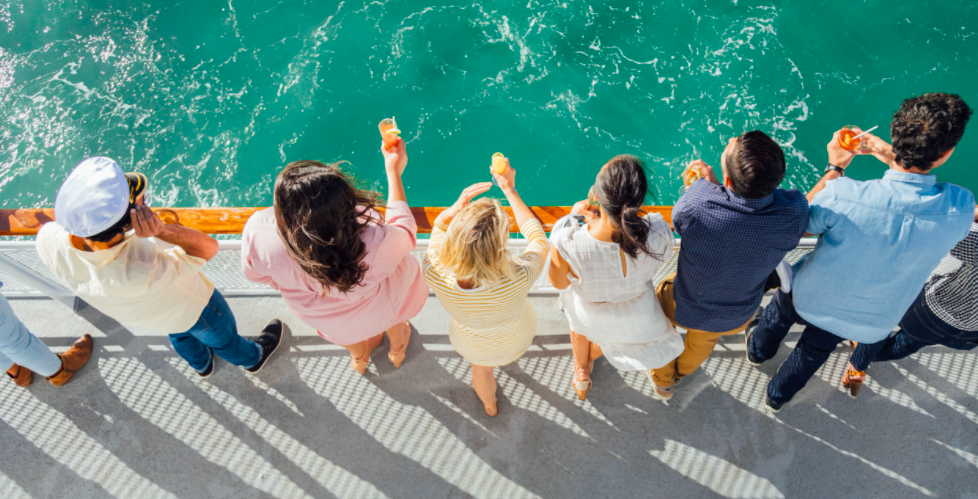 Group of people standing by the railing looking over ocean